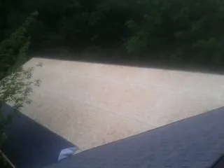 New OSB roof sheathing installed beside an existing shingle roof in Lillian