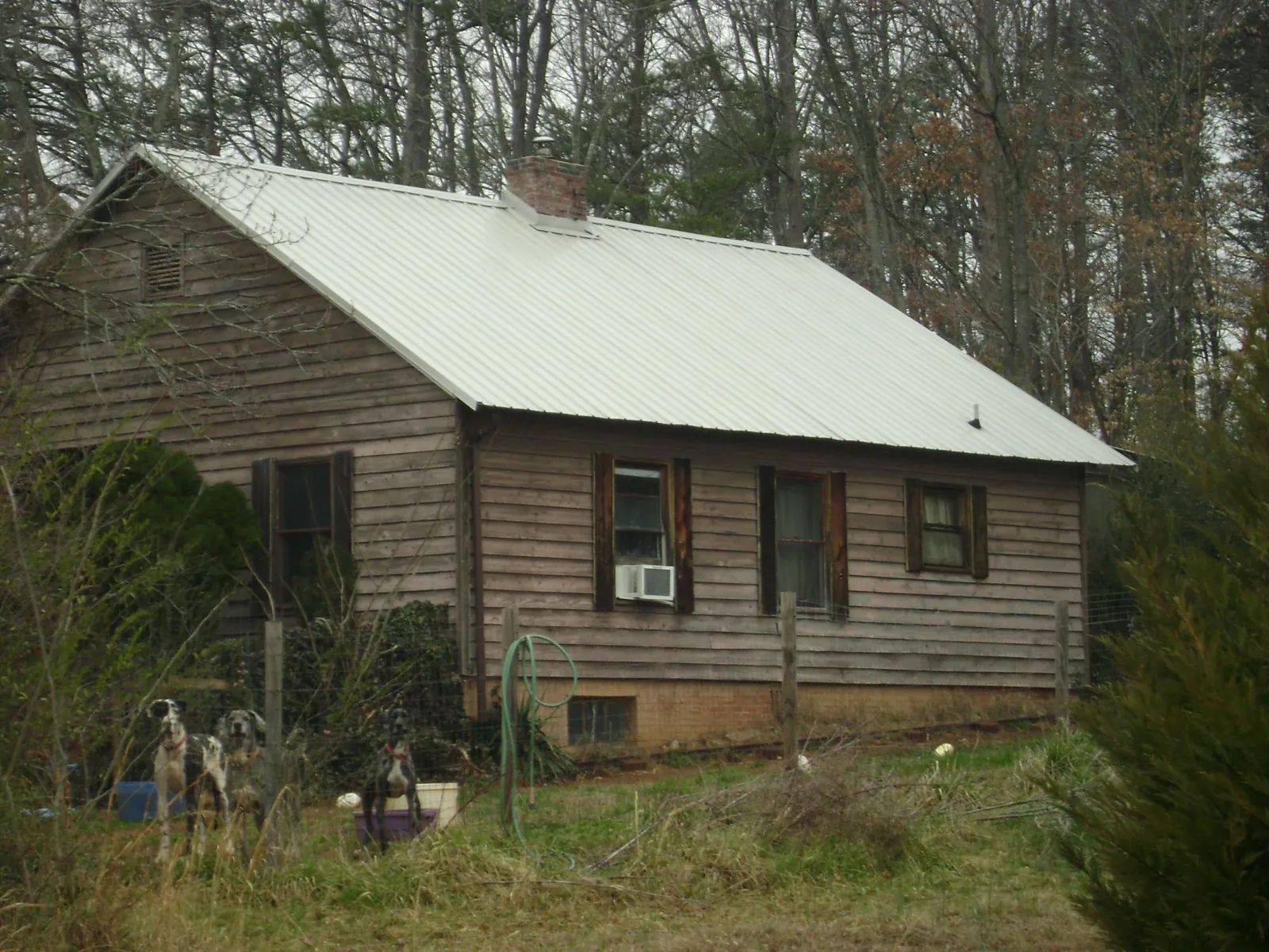 White metal roof on an old wood sided farmhouse, from a Asphalt Shingle Roof Repair job in Lillian